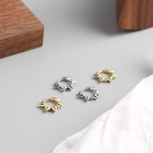 Vue détaillée des boucles d'oreilles punk argent et or avec pierres précieuses noires