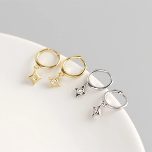 Close-up of gold and silver S925 sterling silver hoop earrings with star charms and zircon