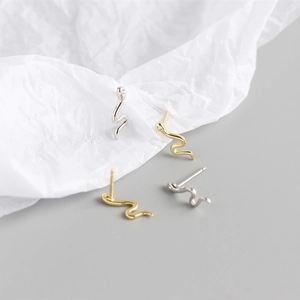 Macro shot of S925 sterling silver snake earrings with gold and silver polished finishes