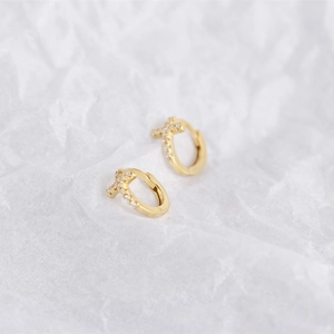 Close-up of gold-plated S925 silver cross earrings with sparkling zircon stones