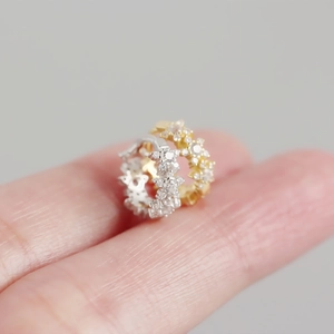 Macro shot of gold and silver S925 sterling silver star hoops with crystal pavé details