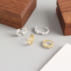 Detailed close-up of gold and silver S925 sterling silver star hoop earrings with crystals