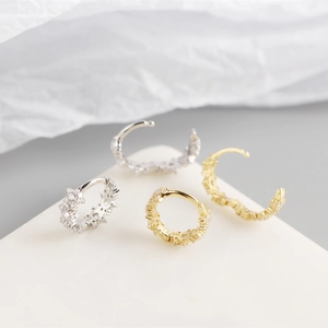 Detail of silver and gold S925 sterling silver hoop earrings with sparkling zircon inlay