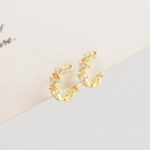 Macro detail of gold-plated silver hoop earrings with pave-set sparkling white zircons