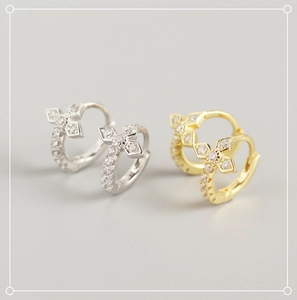 Detail of silver and gold cross hoop earrings with sparkling cubic zirconia stones
