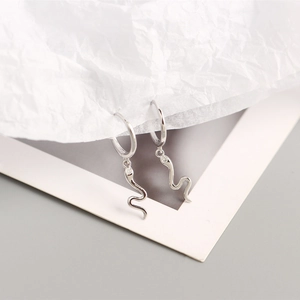 Macro detail of S925 sterling silver snake hoop earrings with zircon stone accents