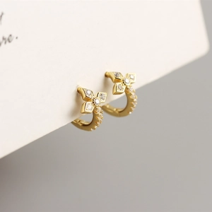 Detailed view of gold-plated clover earrings with sparkling cubic zirconia pavé