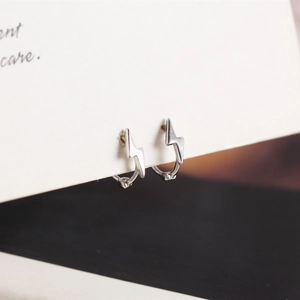 Detailed macro view of S925 sterling silver lightning bolt hoop earrings on a display card