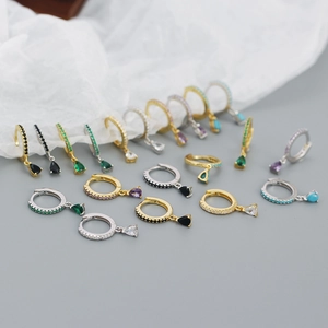 Detailed close-up of colorful pear-cut zircon drop hoop earrings in gold and silver