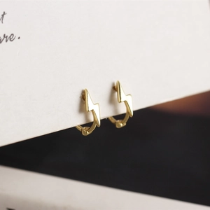Close-up of minimalist gold-plated 925 silver lightning bolt hoop earrings for daily wear