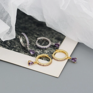 Detail of S925 silver hoop earrings featuring purple teardrop gems and pavé crystals