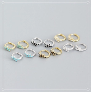 Dettaglio di orecchini huggie in argento S925 con pavé di zirconi colorati lucidi