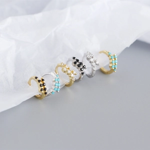 Dettaglio di orecchini a cerchio in argento S925 con zirconi colorati in oro e argento