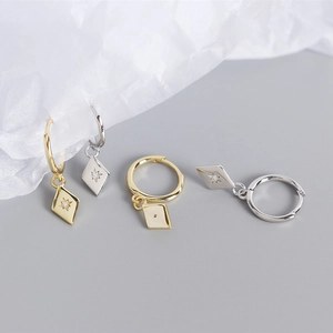 Détail des boucles d'oreilles losange en argent S925 avec gravure étoile et petit zircon