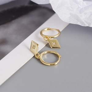 Macro des boucles d'oreilles losanges en argent S925 doré avec motif étoile et zircon