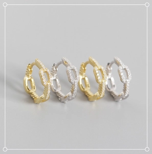 Macro shot of silver and gold chain hoop earrings with micro-pave cubic zirconia crystals