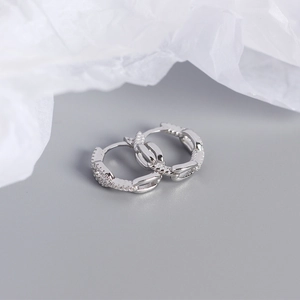 Macro shot of silver chain link hoop earrings featuring exquisite pavé set zircons