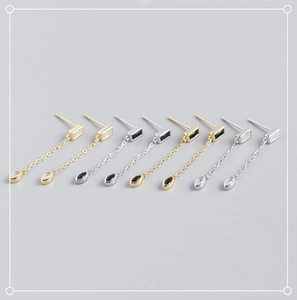 Détail de boucles d'oreilles en argent S925 avec zircons géométriques et fines chaînes