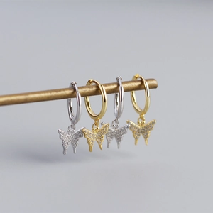 Detail of S925 silver butterfly earrings with sparkling crystals in gold and silver plating