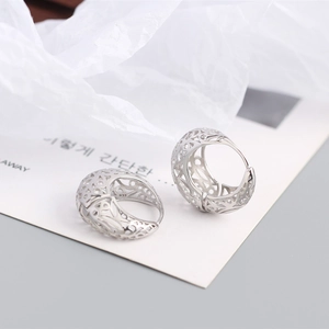 Close-up of S925 sterling silver stamp on ornate hollow geometric hoop earrings