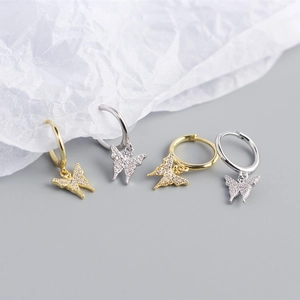 Macro view of crystal butterfly hoop earrings in silver and gold with pavé zircon