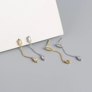 Vue détaillée de boucles d'oreilles pampilles en argent et or avec zircons sur carte