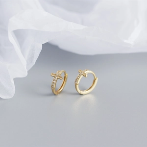 Detailed view of gold cross hoop earrings with shimmering white cubic zirconia stones