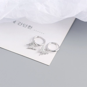 Detailed view of silver S925 butterfly earrings with pavé white rhinestones on a white card