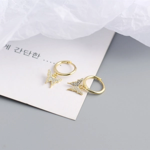 Detail of gold butterfly hoop earrings with white zircon pavé setting on white card
