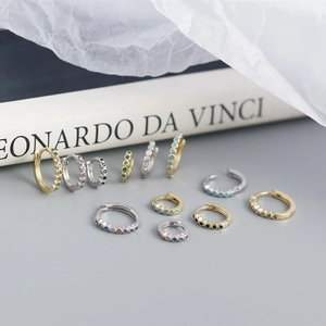 Detail of S925 sterling silver huggie earrings with colorful zirconia in gold and silver