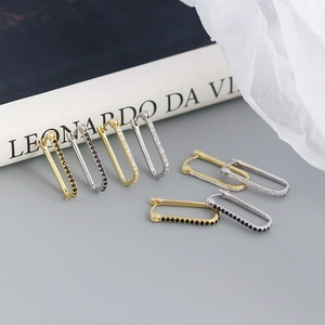 Primer plano de pendientes rectangulares de plata S925 con circonitas en oro y plata mate