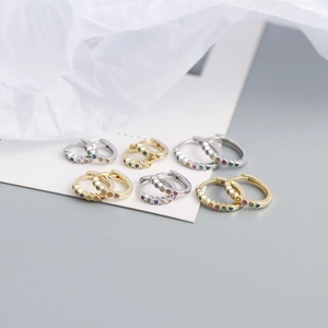 Detailed shot of rainbow zircon hoop earrings in gold and silver plating on white card