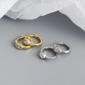 Macro detail of S925 sterling silver hoop earrings with oval-cut cubic zirconia stones