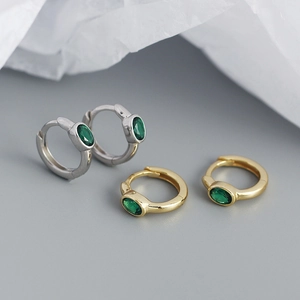 Detail of s925 silver hoop earrings with oval green zircon in gold and silver finishes