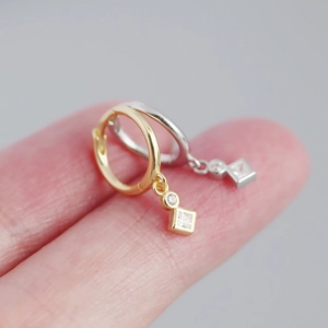 Macro view of gold and silver S925 geometric hoop earrings with clear zircon stones