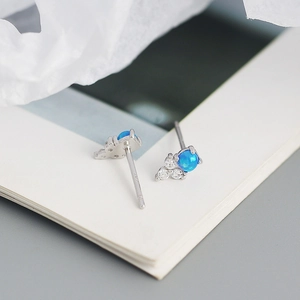 Gros plan de puces d'oreilles en argent S925 avec opale bleue et petits zircons blancs