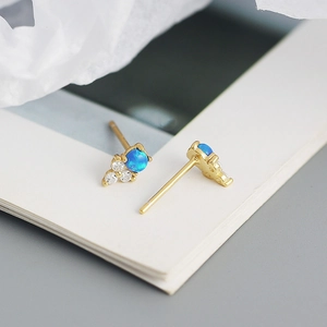Gros plan sur des boucles d'oreilles en argent S925 doré avec opale bleue et zircon