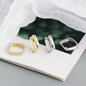 Détail du poinçon S925 sur des créoles carrées minimalistes en or et en argent sterling