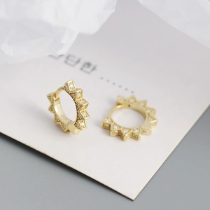 Macro detail of S925 sterling silver gold ear hoops with pavé-set cubic zirconia
