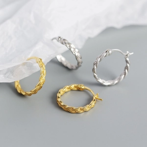 Dettaglio degli orecchini a cerchio intrecciati in argento S925 oro e argento