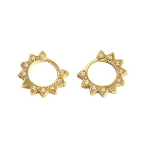 Golden sunburst huggie hoop earrings with white crystals on a minimalist white background