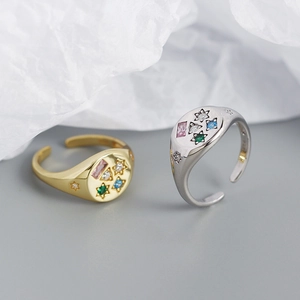 Detailed macro of gold and silver signet rings with colorful zircons and star engraving