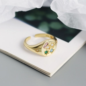 Close-up of S925 stamp on a gold-plated ring with colorful star-set zircons
