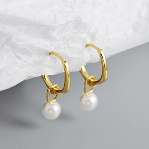 Close-up of S925 silver stamp on gold-plated hoop earring with white pearl pendant