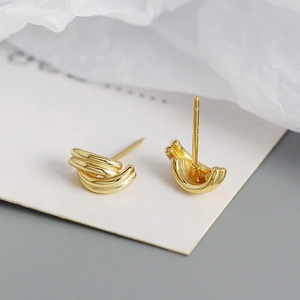 Macro shot of triple-layer gold geometric earrings with a polished metallic finish