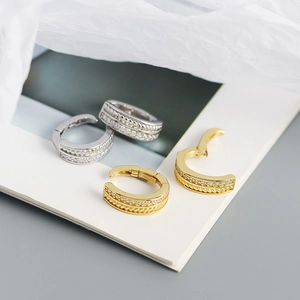 Close-up of gold and silver twisted hoop earrings with micro-pave cubic zirconia
