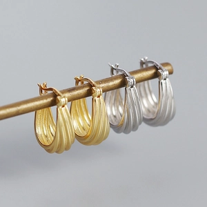 Detail shot of gold and silver S925 sterling silver geometric spiral earrings