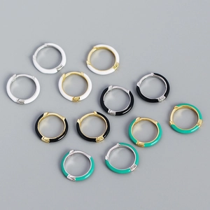 Vue macro détaillée de boucles d'oreilles huggie en argent S925 et émail coloré