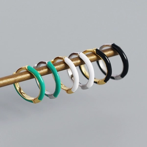Détail de boucles d'oreilles créoles en émail minimaliste en vert, blanc et noir élégant