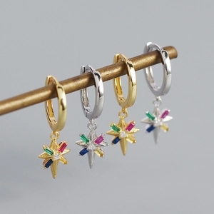 Detalle macro de pendientes de estrella de ocho puntas con piedras de colores vivos